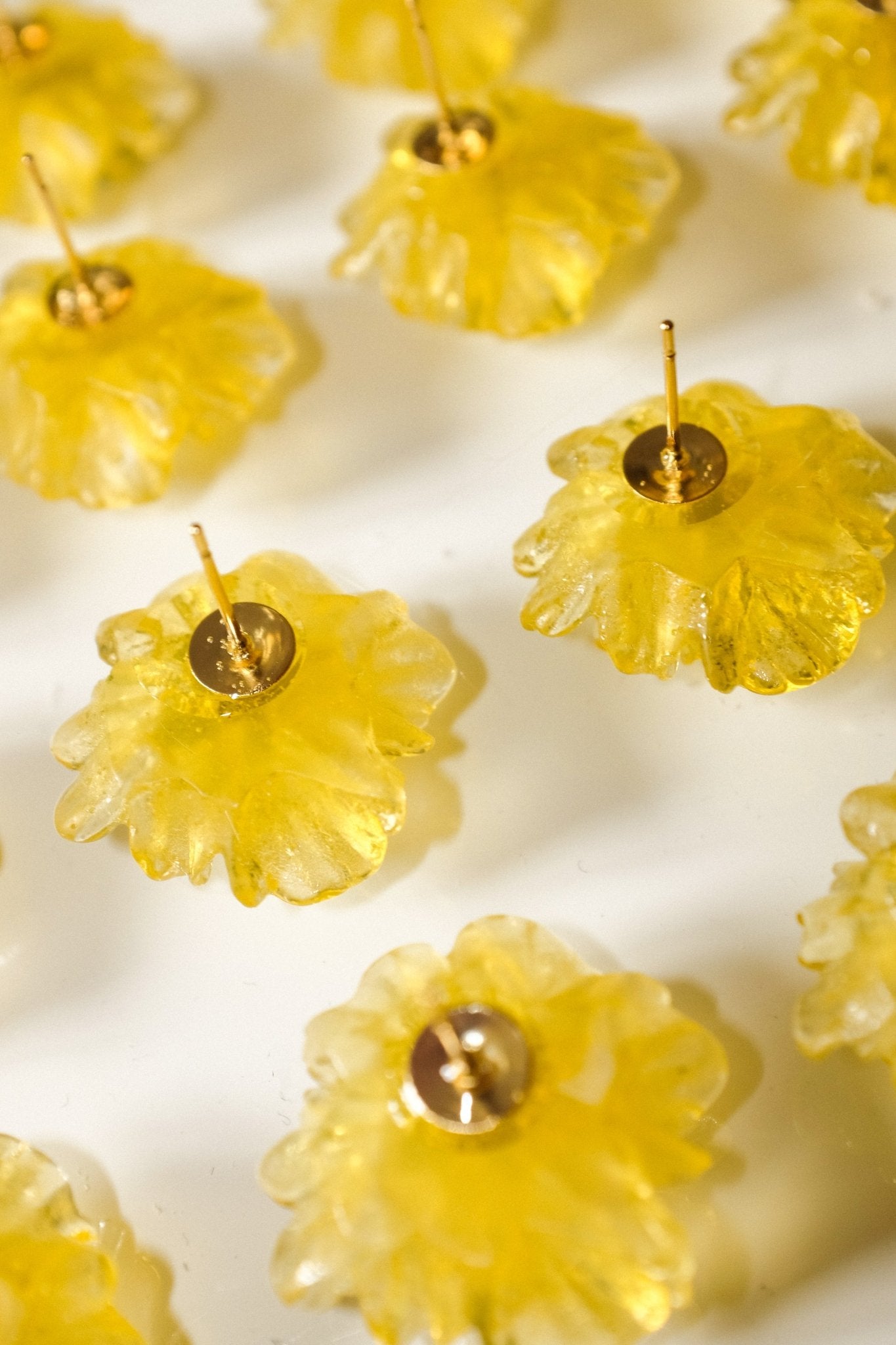 Yellow flower-shaped earrings on a white background