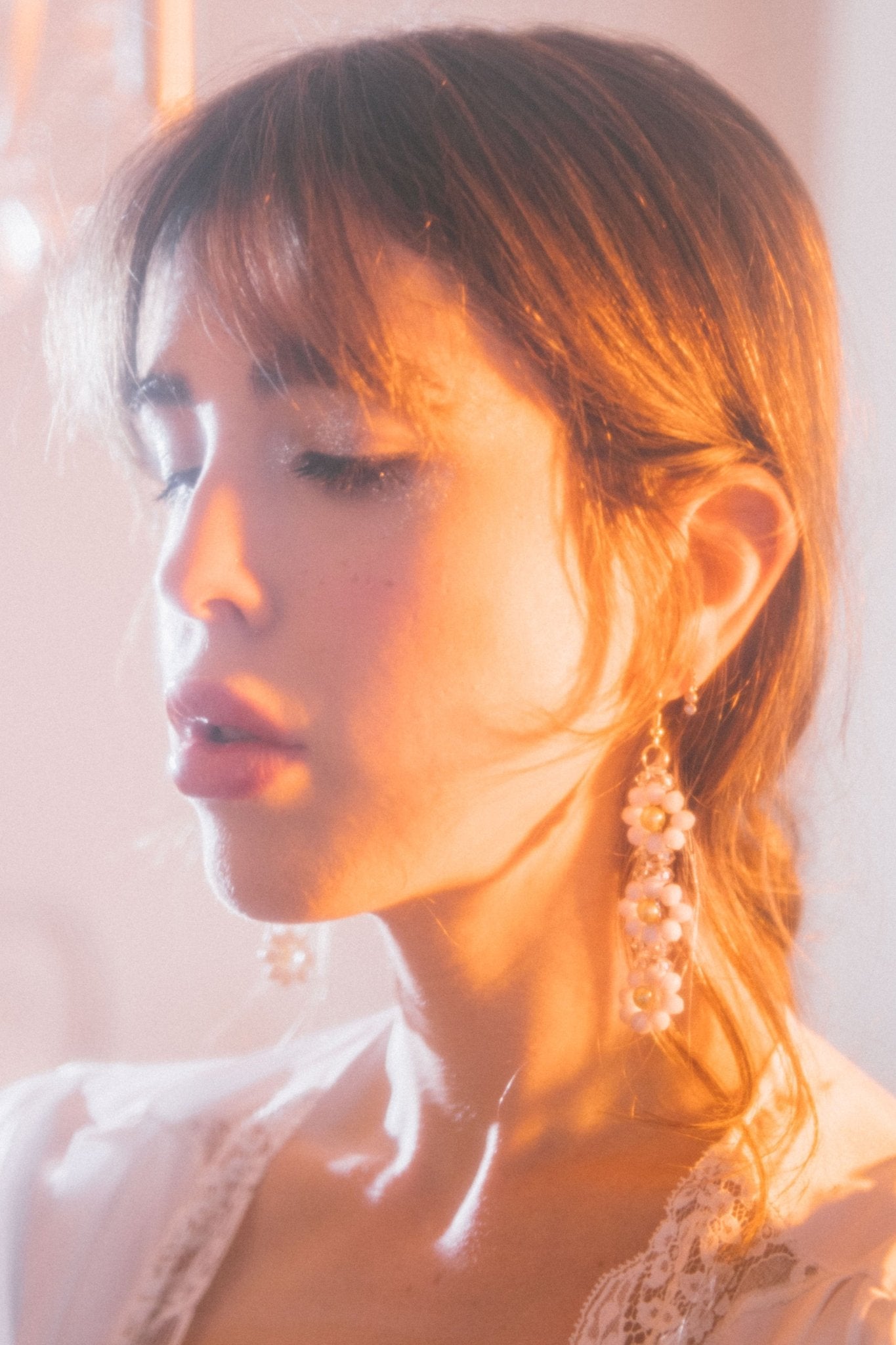 Close-up of Marguerite Earrings with cream faceted glass rondelles and gold faux pearls
