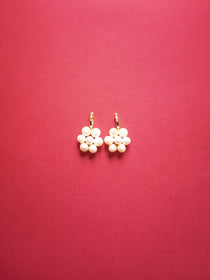 Billy Mini Hoop Earrings displayed against a red background