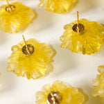 Yellow flower-shaped earrings on a white background